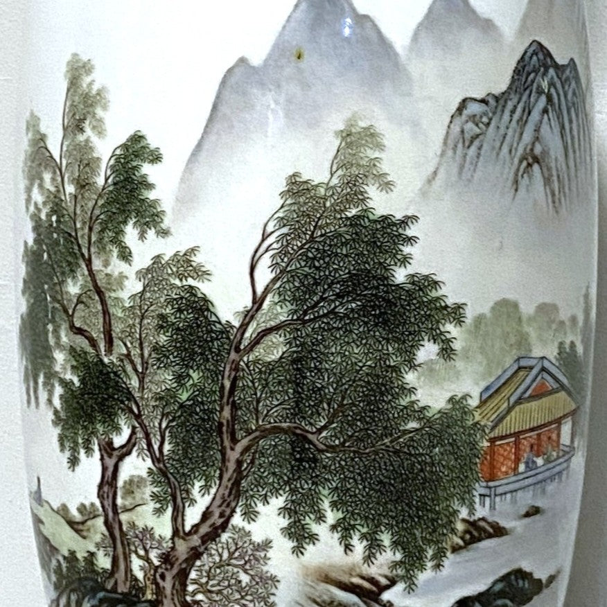 Decorative vase with a landscape design featuring trees and a building.